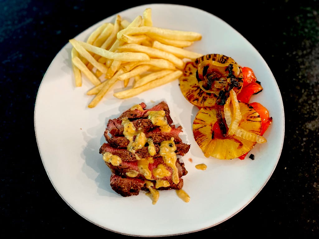 Fries, steak in pepper sauce, grilled pineapples and peppers